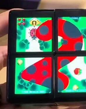 A bright arcade game running across WOWCube