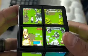 Hands holding WOWCube playing a pixel adventure game
